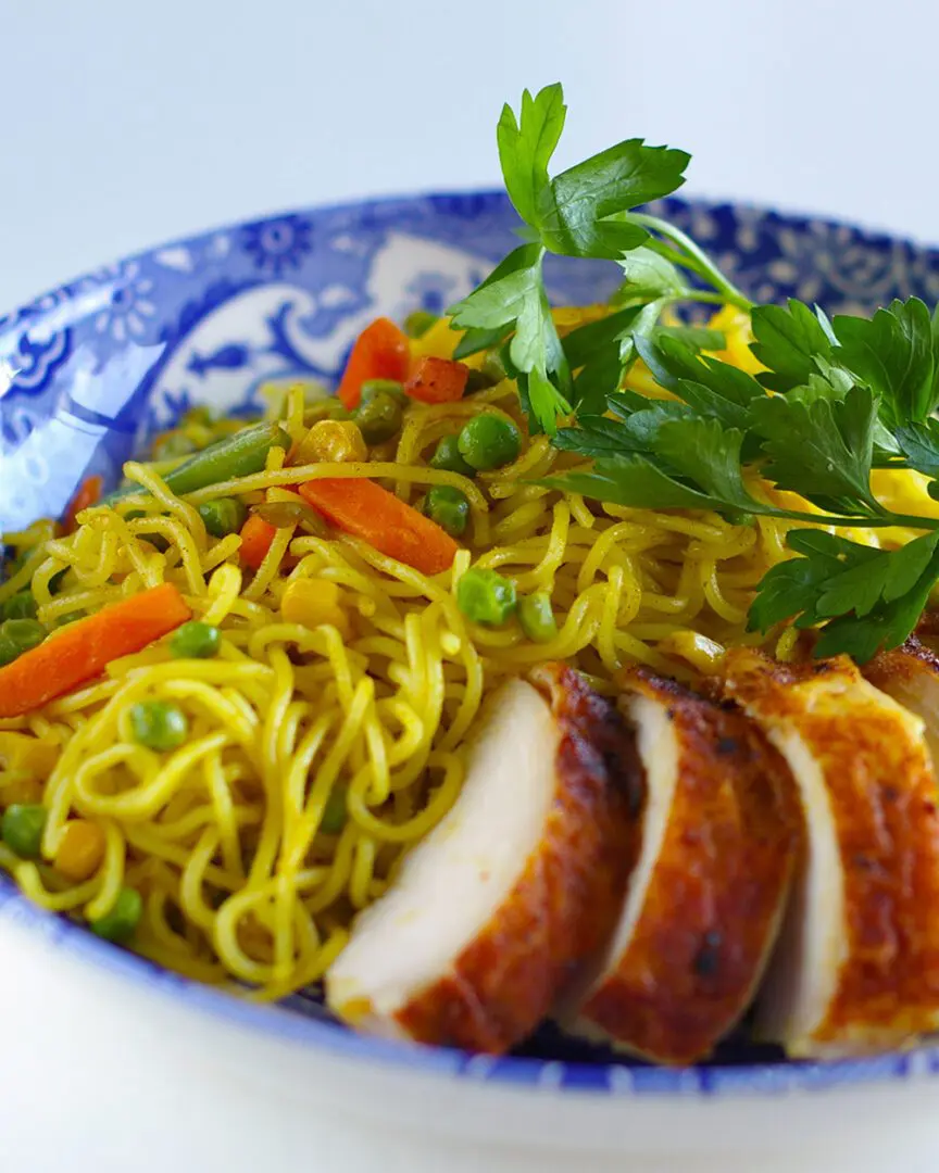 Signature Curry Yakisoba mixed with frozen vegetables topping with rotisserie chicken