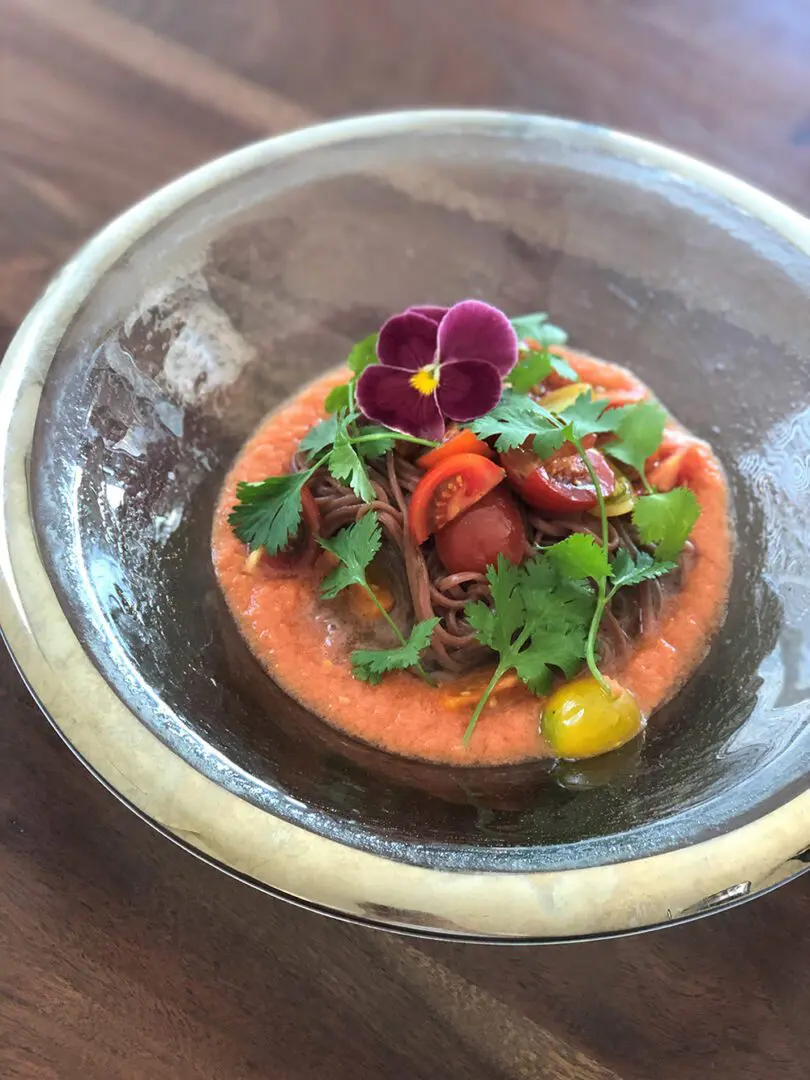 Beet Noodles with chilled tomato soups topping with cherry tomatoes and cilantro