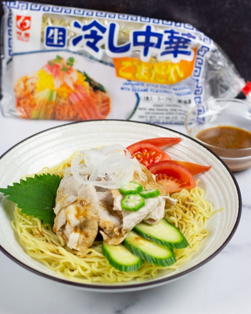 Sesame hiyashi chuka (cold ramen) topping with chilled pork shabu shabu, cucumber, tomato, okra, and onion