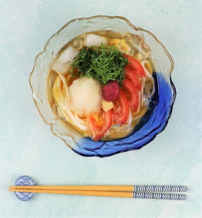 A bowl of cold udon topping with tomato, daikon oroshi (grated daikon radish), shiso, and umeboshi (pickled plum)