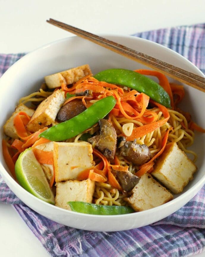 Yakisoba mixed with tofu cutlet, carrot, snow peas, mushrooms, and peanut butter