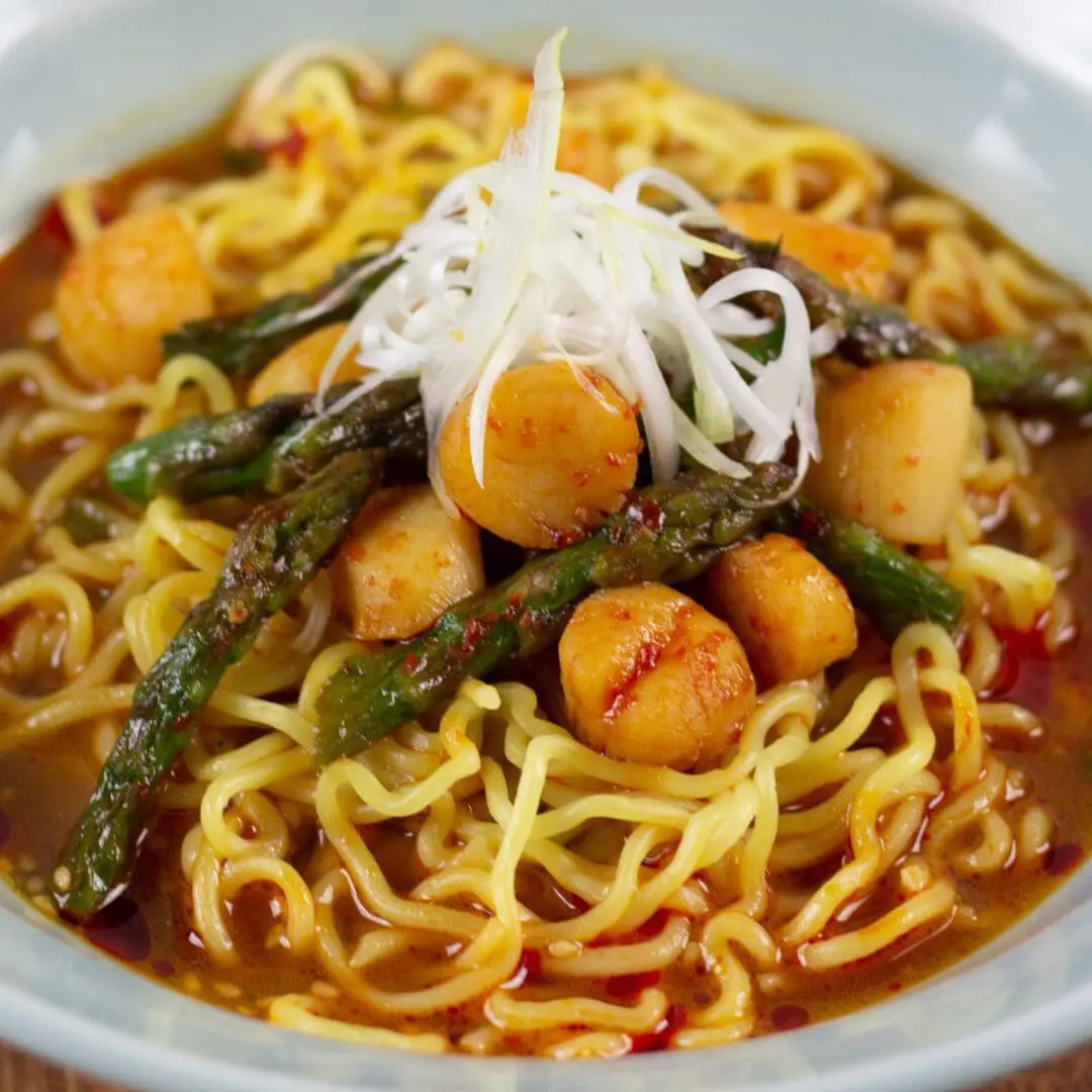 Signature Miso Ramen topping with fresh asparagus and baby scallops with doubanjiang