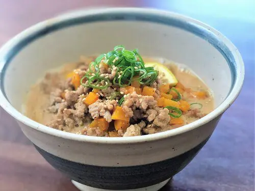 Signature Miso Ramen with soup mixed with soy milk topping with ground pork and sweet yellow bell peppers