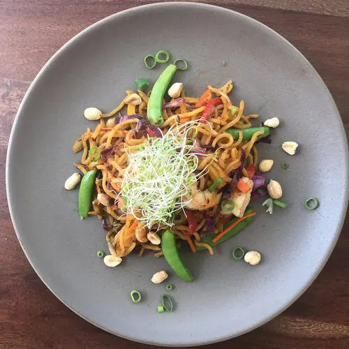 Yakisoba mixed with shrimps, kimchi, and rainbow vegetables including carrots, red pepper, yellow pepper, purple cabbage