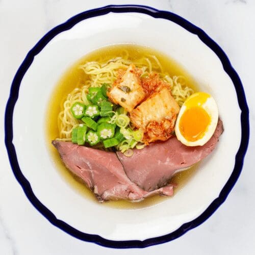 Signature Shio Chicken Ramen top with okra, spicy kimchi, sliced roast beef, scallions, and ramen egg