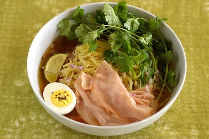 Signature Shio Ramen topping with turkey ham, salted eggs, red onion, cilantro with lime