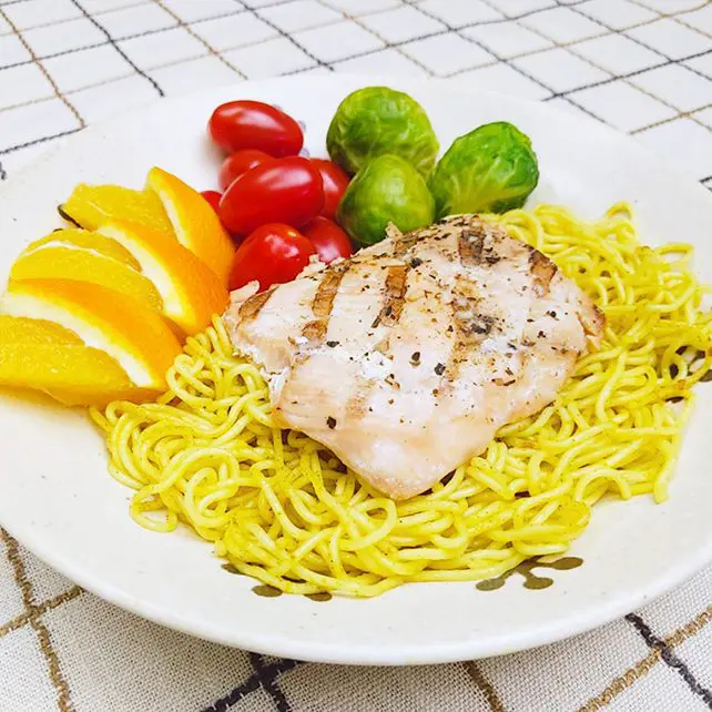 Grilled salmon with curry yakisoba topping with brussel sprouts, mini tomatoes, and oranges