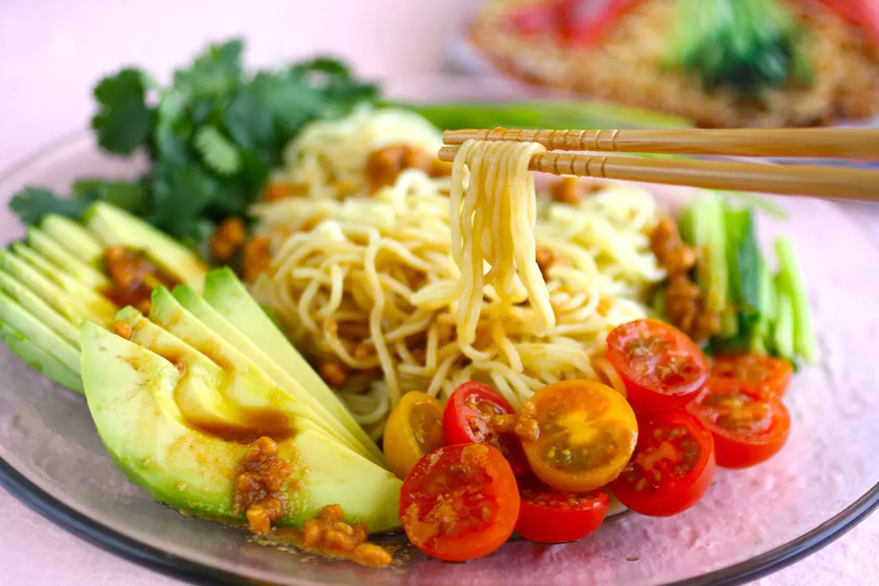 Hiyashi chuka (cold ramen) with peanut sauce topping with tomato, avocado, and cucumber