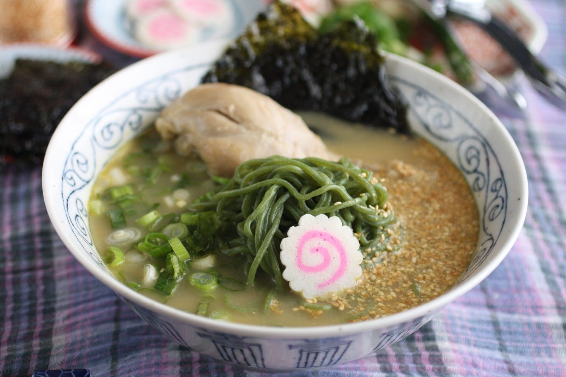 Kale Ramen with garlic chicken soup topping with roasted sesame seeds, seaweed (nori), garlic, spring onion, naruto (fish cake)