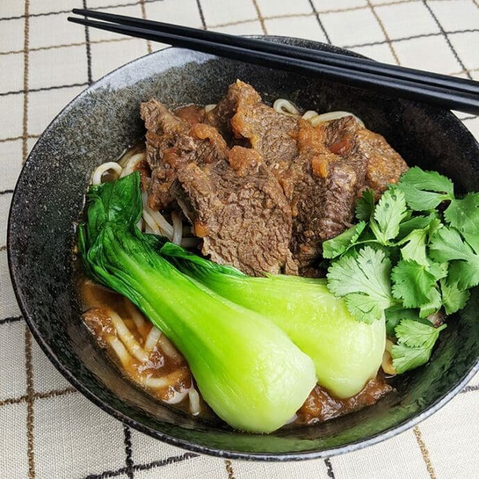 Myojo-style Beef Noodle Soup made of stewed beef, beef broth, and vegetables topping with bok choy and cilantro