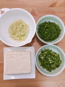 Ingredients for Plant-Based Gyoza (tofu), Tofu, green onion, Chinese chives, and cabbage