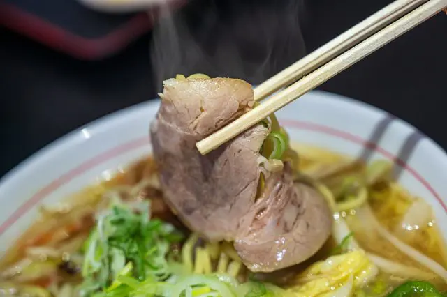 Chashu pork lifted with chopsticks