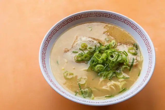 Ramen noodles served in a bowl with a Raimon pattern painted on it