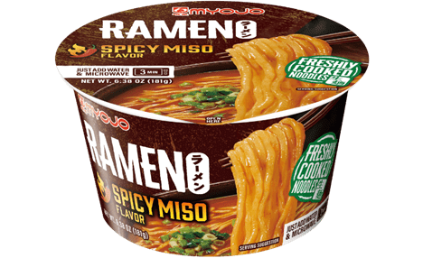 Myojo Spicy Miso Ramen cup showing a bowl of spicy miso soup with noodles, green onions, and a label reading 'Freshly Cooked Noodles' and 'Ready in 3 minutes in the microwave'